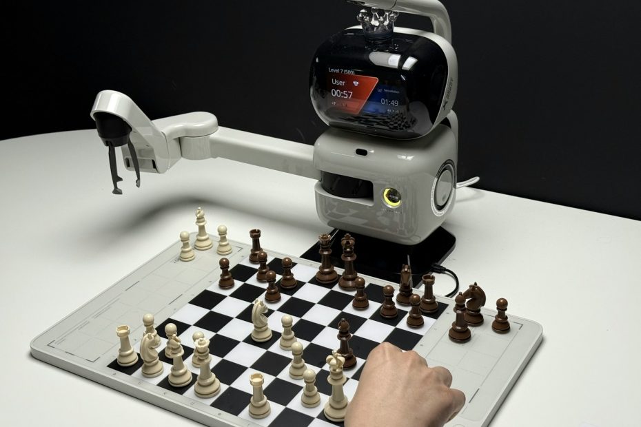 Robot arm playing chess against a human opponent.